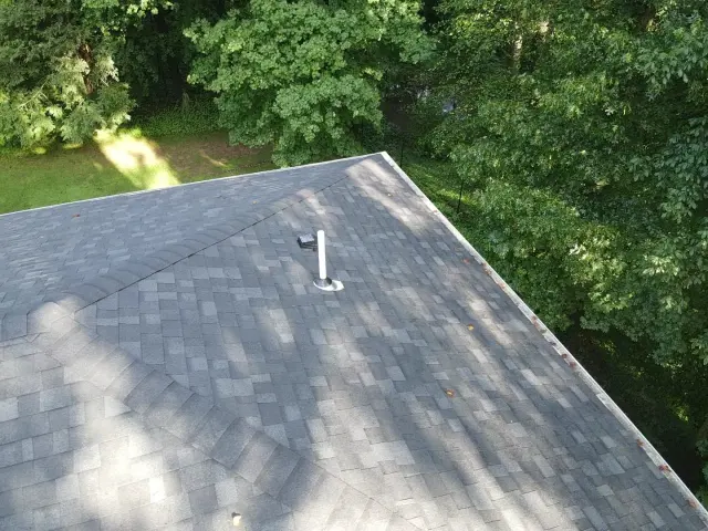 Plumbing vent pipe with a new boot and a box vent on a gray architectural shingle roof