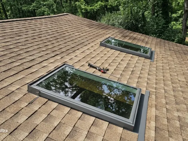 Two skylights set in new step-flashing kits on a tan shingle roof