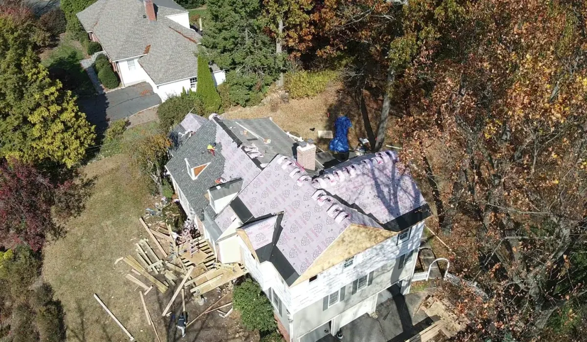 Storm-damaged shingles and a tarped roof on a New Jersey home documented for an insurance claim