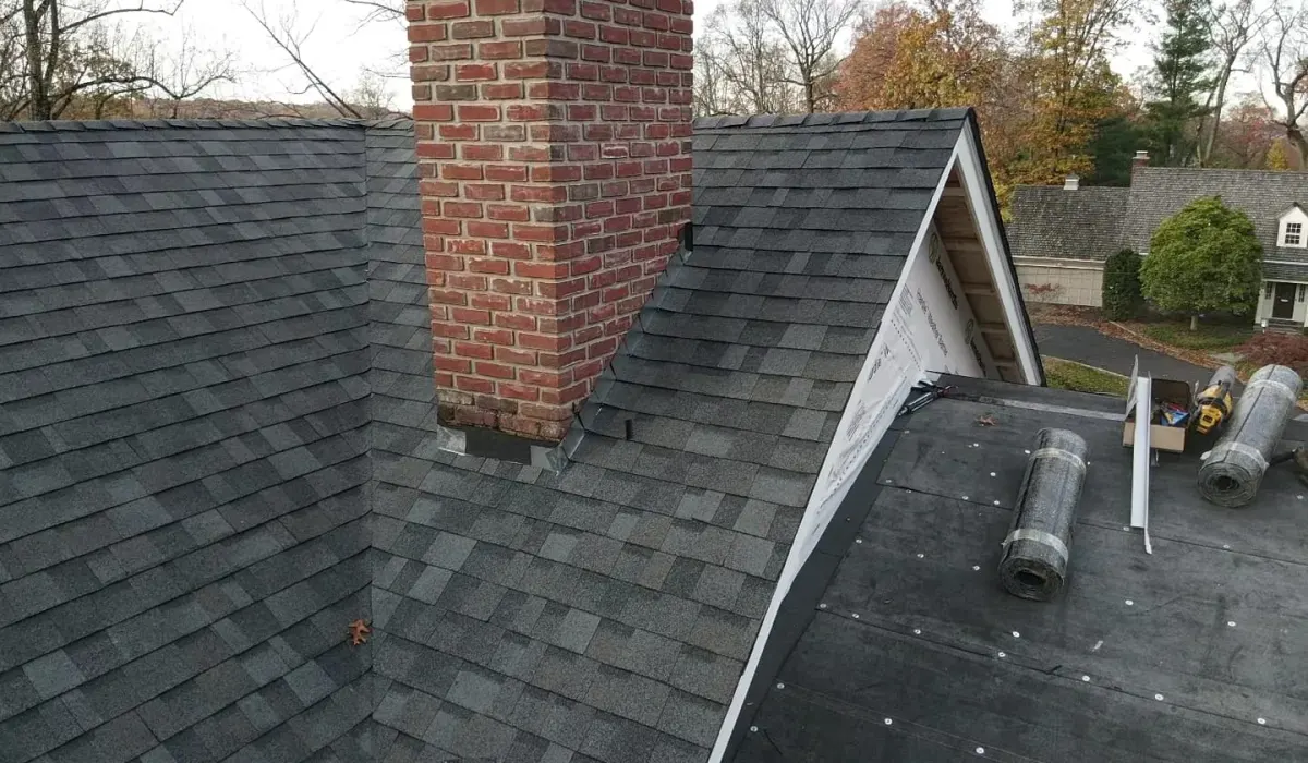 New step and counter flashing installed where a brick chimney meets the shingle field on a New Jersey roof