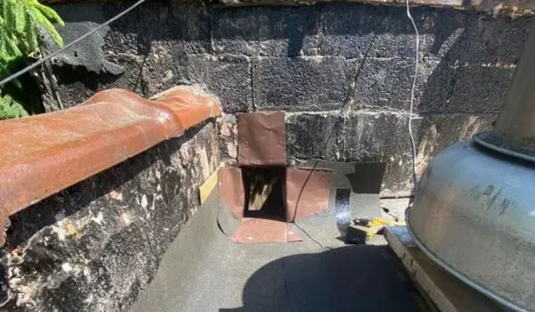 A parapet wall and scupper drain on a low-slope flat roof in New Jersey, where drainage and flashing problems usually begin