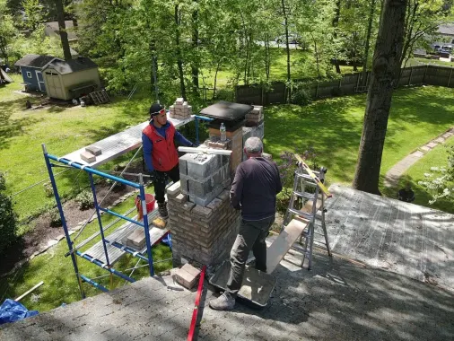 Two crew members on scaffolding working out a chimney rebuild